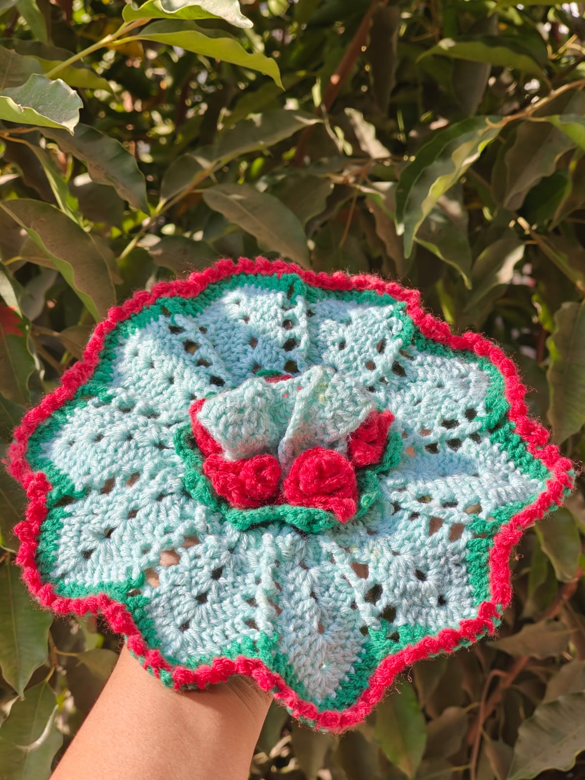 Mini green amigurumi dinosaur plush in textured stitch, small enough to fit in a pocket.