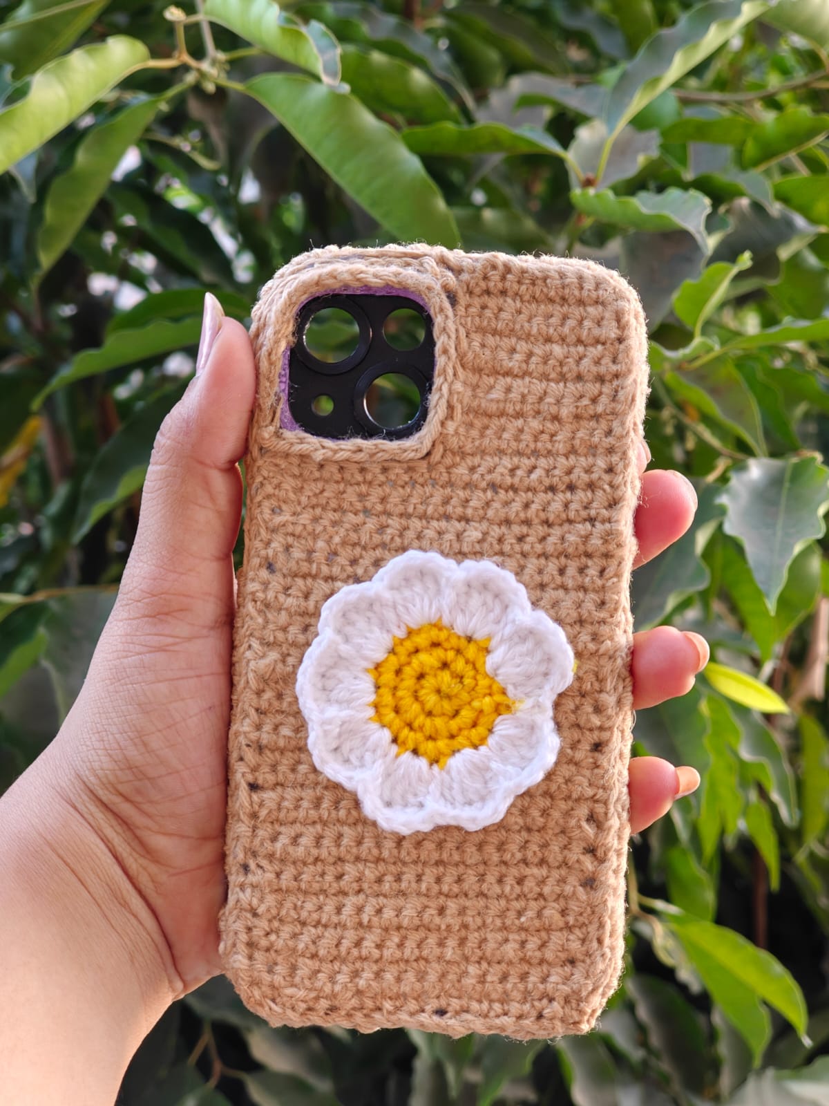Compact crochet coin purse with a bronze clasp frame and floral granny square layout.
